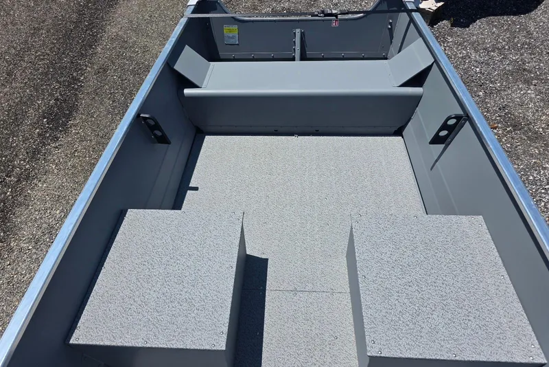 Slide: The Image of 2026 Smoker Craft Alaskan 15 TS DLX boat interior with gray seating and flooring. - 6