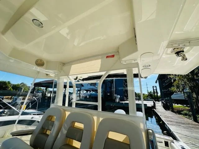 Slide: The Image of Interior view of 2023 Boston Whaler 360 Outrage boat with seating and dock in background. - 20