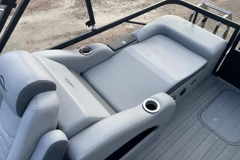 Slide: The Image of 2026 SunCatcher Fusion 322SS boat interior with gray seating and cup holders. - 11