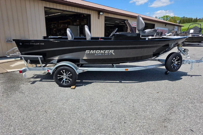 The Image of 2026 Smoker Craft Pro Angler 165 SC boat on trailer, parked outdoors. - 0