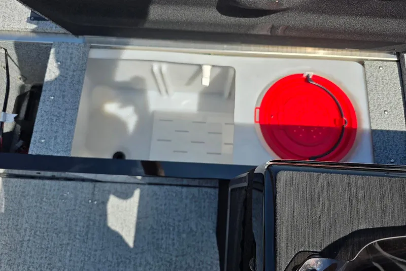 Slide: The Image of 2026 Smoker Craft Pro Angler 165 SC boat interior with storage compartment and red bucket. - 10