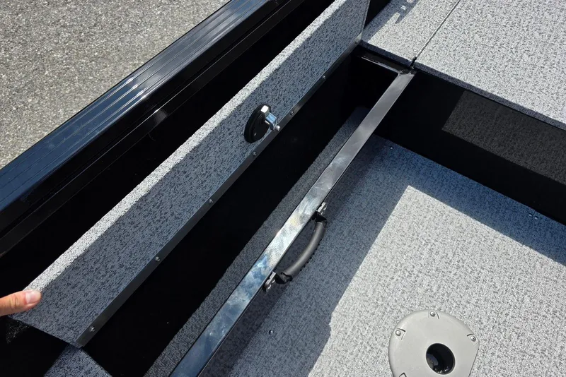 Slide: The Image of 2026 Smoker Craft Pro Angler 165 SC boat storage compartment with textured flooring. - 16
