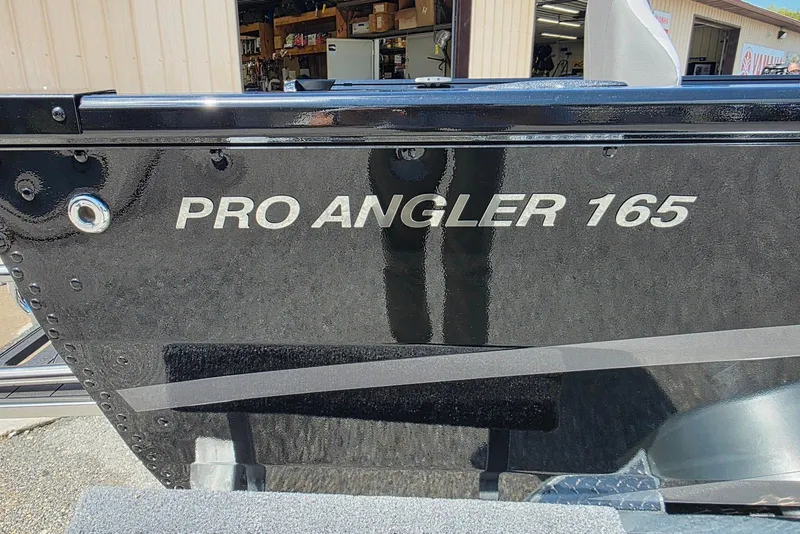 Slide: The Image of 2026 Smoker Craft Pro Angler 165 SC boat, black exterior, close-up view. - 4