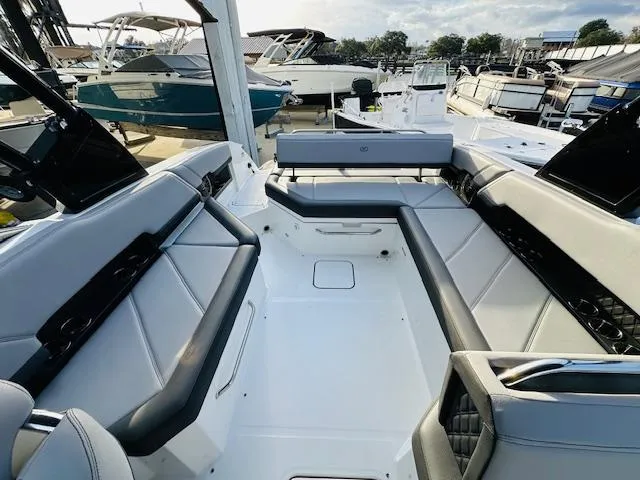 Slide: The Image of 2022 Cobalt R8 boat interior with sleek seating, docked among other boats. - 12