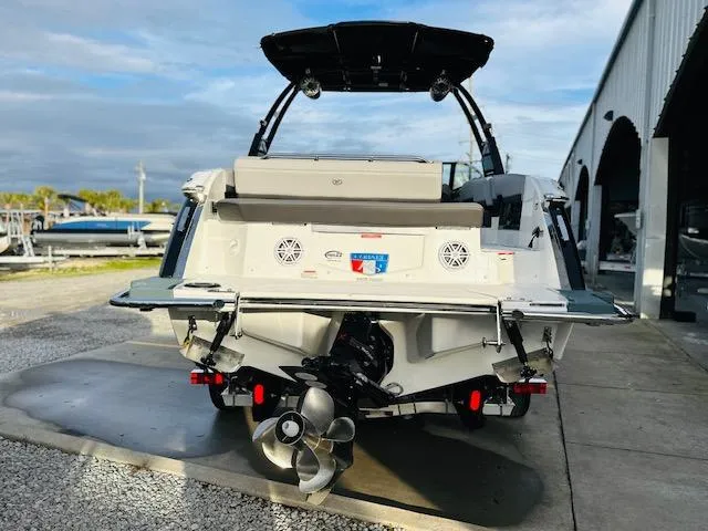 Slide: The Image of 2022 Cobalt R8 boat rear view, showcasing propeller and speakers, parked near a marina. - 3
