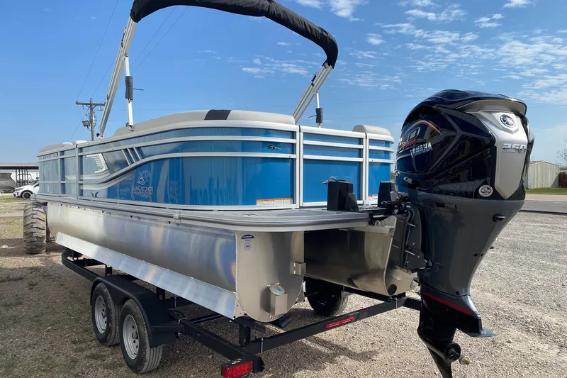 Slide: The Image of 2026 SunCatcher Select 322RC pontoon boat with Yamaha engine on trailer, under blue sky. - 4