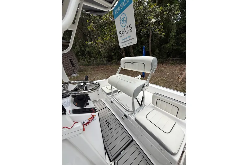 Slide: The Image of 2020 Yamaha Boats 195 FSH Sport interior with seating and steering wheel, for sale sign visible. - 11