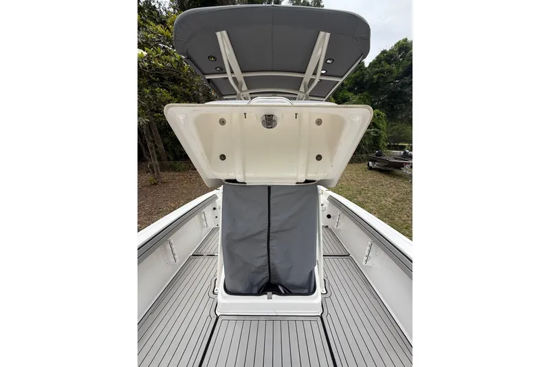 Slide: The Image of 2020 Yamaha Boats 195 FSH Sport interior with open storage compartment and T-top canopy. - 15