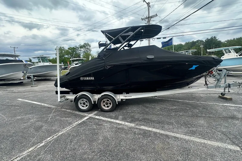 Slide: The Image of 2023 Yamaha Boats 222XD covered on trailer in parking lot, overcast sky. - 10