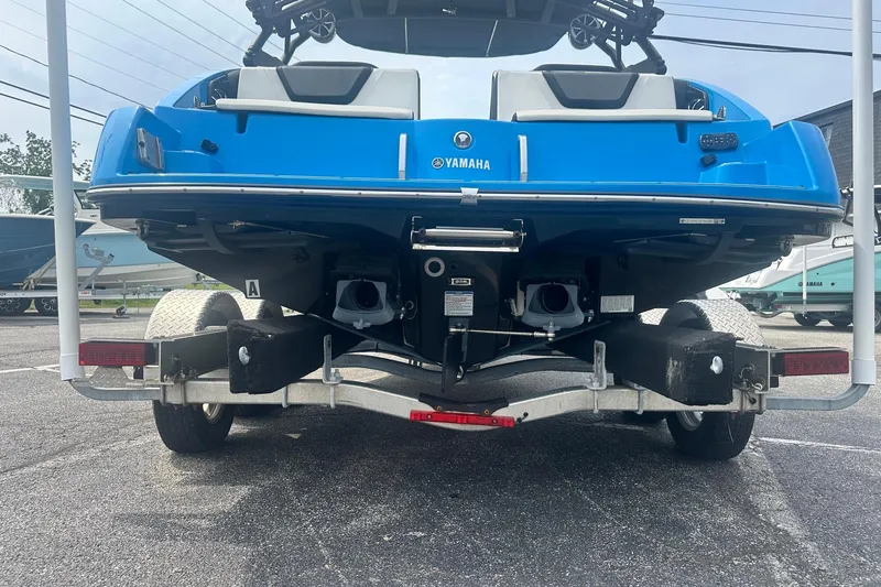 Slide: The Image of 2023 Yamaha Boats 222XD in blue on a trailer, rear view. - 12
