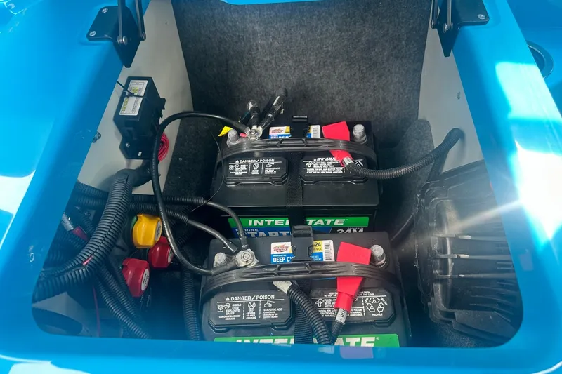 Slide: The Image of 2023 Yamaha Boats 222XD battery compartment with dual marine batteries and wiring. - 19