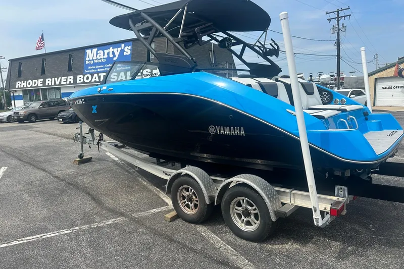 Slide: The Image of 2023 Yamaha Boats 222XD in blue and black on a trailer at Rhode River Boat Sales. - 2