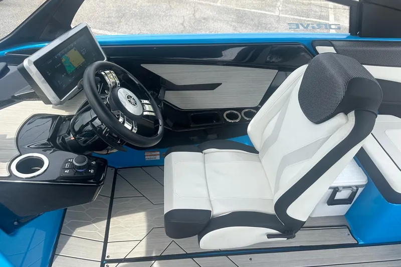 Slide: The Image of 2023 Yamaha Boats 222XD cockpit with steering wheel, touchscreen, and white captain's chair. - 28