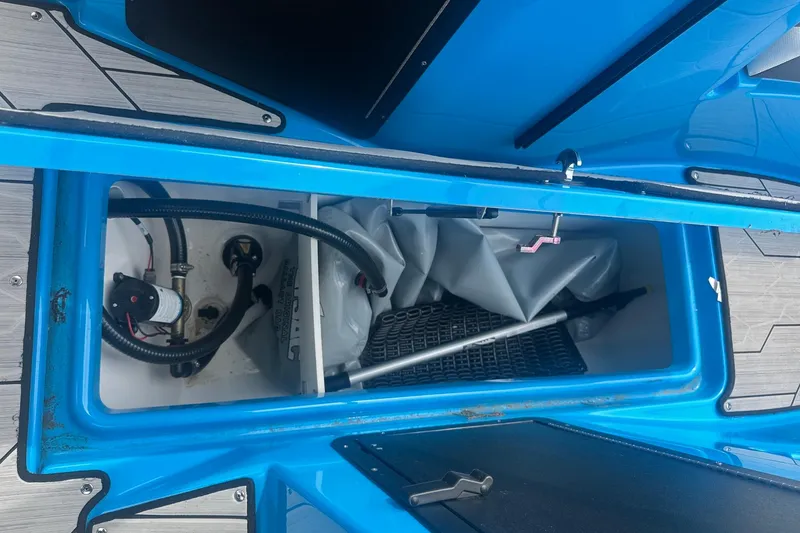 Slide: The Image of 2023 Yamaha Boats 222XD storage compartment with equipment and hoses. - 33
