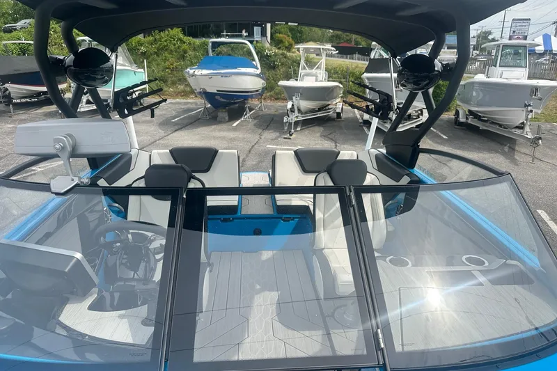 Slide: The Image of 2023 Yamaha Boats 222XD interior with sleek design and modern features, parked among other boats. - 35