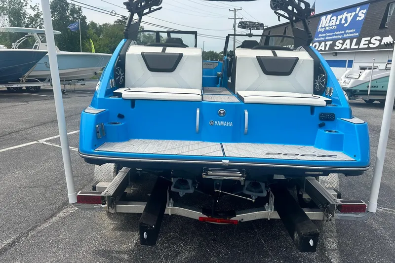 Slide: The Image of 2023 Yamaha Boats 222XD in vibrant blue, displayed at a boat sales lot. - 8