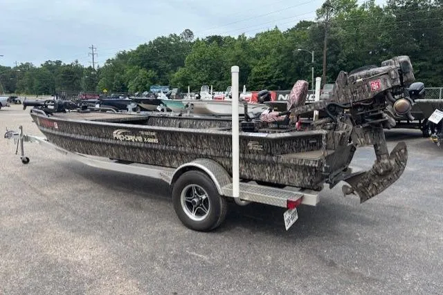 Slide: The Image of 2022 Pro-Drive X SERIES TD EDITION 1854 boat on trailer, camo design, parked outdoors. - 4