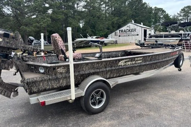 Slide: The Image of 2022 Pro-Drive X SERIES TD EDITION 1854 boat on trailer, camo design, parked outdoors. - 7