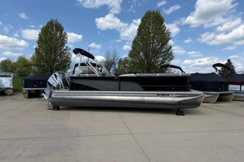 The Image of 2023 Crest Classic DLX 240 SLC pontoon boat parked outdoors under a blue sky. - 0