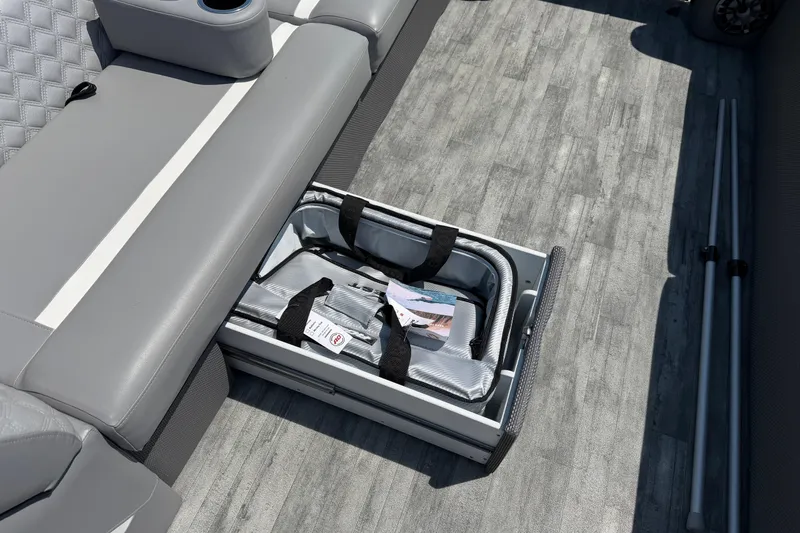 Slide: The Image of 2023 Crest Classic DLX 240 SLC boat interior with storage compartment and gray seating. - 13