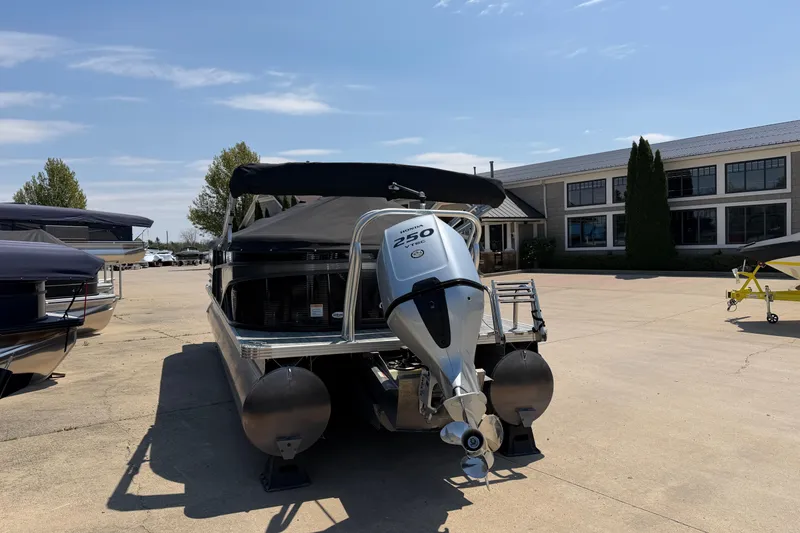 Slide: The Image of 2023 Crest Classic DLX 240 SLC pontoon boat with Honda 250 engine, parked outdoors. - 2