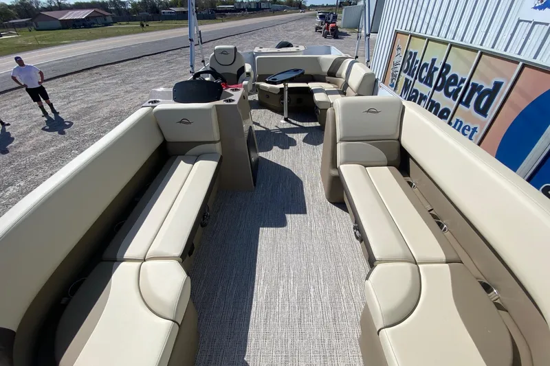 Slide: The Image of 2026 SunCatcher Select 22RF pontoon boat interior with beige seating and steering console. - 5