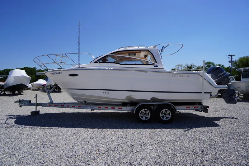 The Image of 2019 Cutwater C-242 Sport Coupe boat on trailer, parked outdoors under clear blue sky. - 1