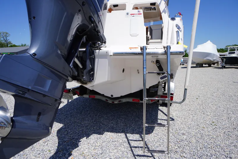 Slide: The Image of 2019 Cutwater C-242 Sport Coupe boat with ladder and outboard motor on gravel. - 12