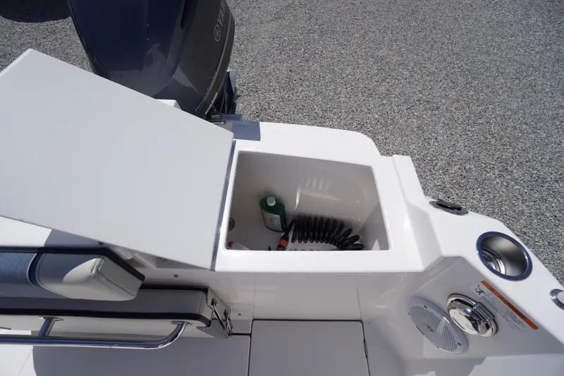 Slide: The Image of 2019 Cutwater C-242 Sport Coupe boat storage compartment with coiled hose and bottle. - 19