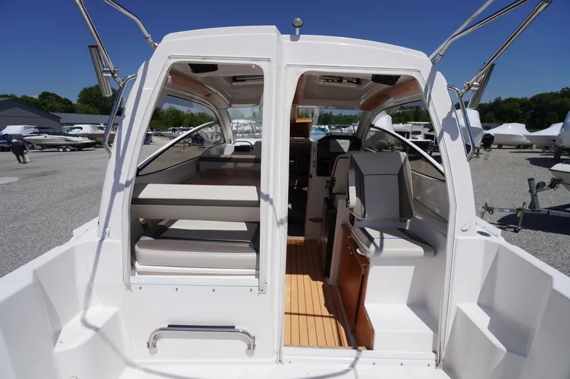 Slide: The Image of 2019 Cutwater C-242 Sport Coupe interior with seating and helm, docked outdoors. - 24