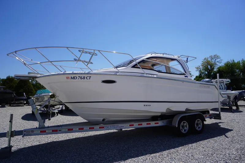 Slide: The Image of 2019 Cutwater C-242 Sport Coupe boat on trailer, parked outdoors under clear blue sky. - 3