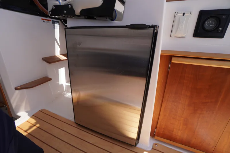 Slide: The Image of 2019 Cutwater C-242 Sport Coupe interior with stainless steel fridge and wooden cabinetry. - 36