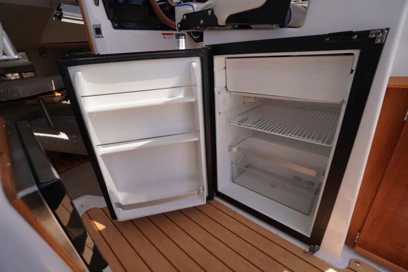 Slide: The Image of Open refrigerator inside 2019 Cutwater C-242 Sport Coupe boat, showcasing interior storage space. - 37