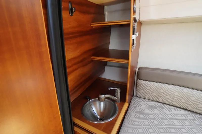 Slide: The Image of 2019 Cutwater C-242 Sport Coupe interior with wooden shelves and compact sink. - 58