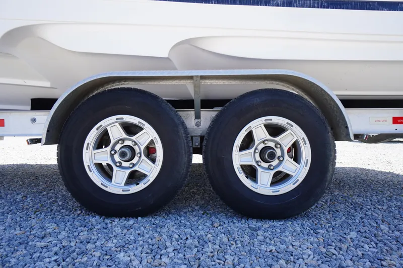 Slide: The Image of Trailer wheels of a 2019 Cutwater C-242 Sport Coupe on gravel surface. - 6