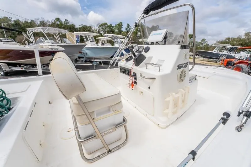 Slide: The Image of 2005 Century 1902 Inshore boat interior with seating and control panel, parked among other boats. - 10