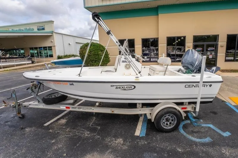 Slide: The Image of 2005 Century 1902 Inshore boat on trailer, parked outside a building. - 7
