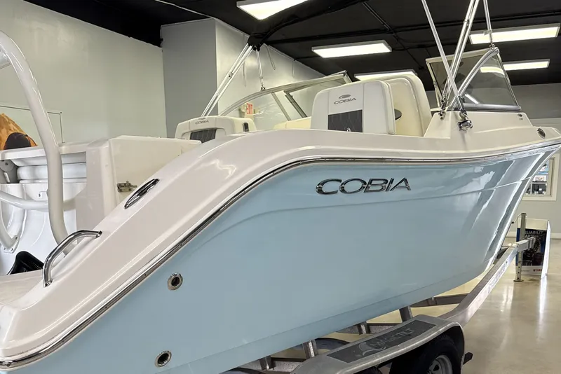 Slide: The Image of 2024 Cobia 220 Dual Console boat in showroom. - 5