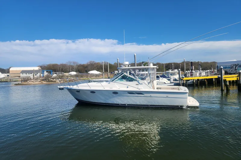 Slide: The Image of 2003 Tiara Yachts 3100 Open LE boat docked in a marina under clear blue skies. - 1