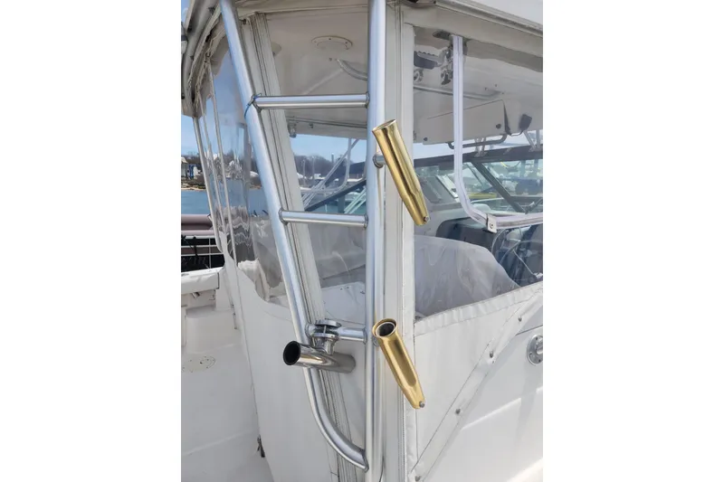 Slide: The Image of 2003 Tiara Yachts 3100 Open LE boat with rod holders and clear enclosure. - 13