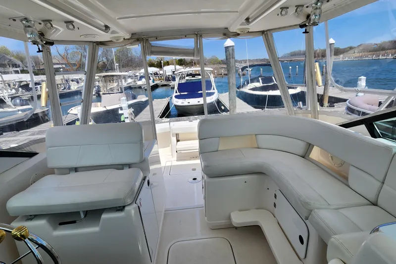 Slide: The Image of Interior view of 2003 Tiara Yachts 3100 Open LE, featuring white seating and marina backdrop. - 16