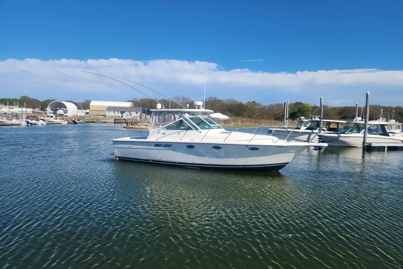 Slide: The Image of 2003 Tiara Yachts 3100 Open LE in a marina, clear sky, calm waters. - 2