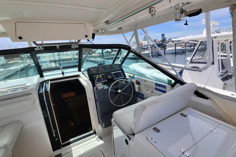 Slide: The Image of 2003 Tiara Yachts 3100 Open LE cockpit with steering wheel and marina view. - 21