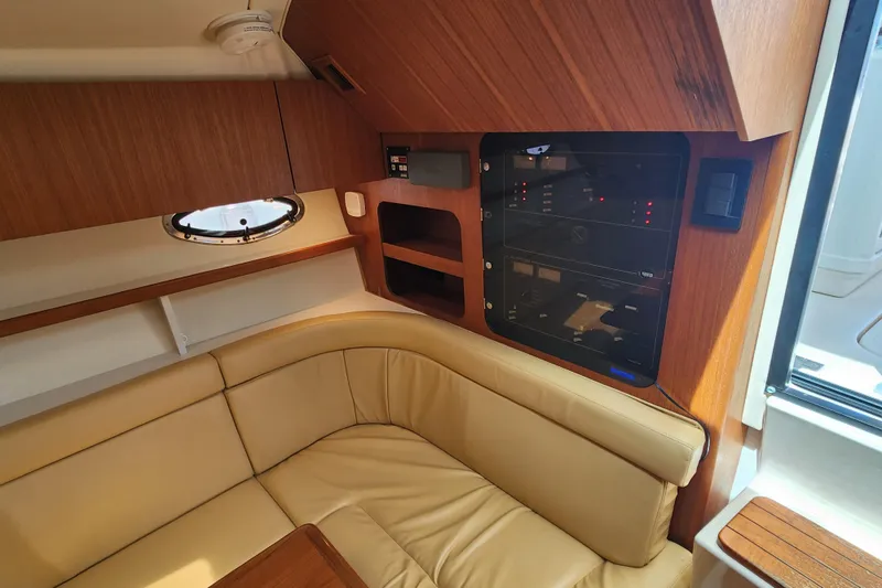 Slide: The Image of Interior of 2003 Tiara Yachts 3100 Open LE with beige seating and wood paneling. - 26