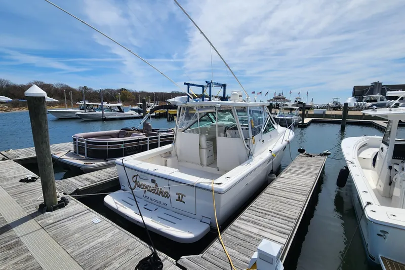 Slide: The Image of 2003 Tiara Yachts 3100 Open LE docked at marina under blue sky. - 3