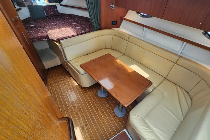 Slide: The Image of Interior of 2003 Tiara Yachts 3100 Open LE with cozy seating and wooden table. - 31