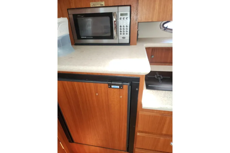 Slide: The Image of 2003 Tiara Yachts 3100 Open LE galley with microwave and wooden cabinetry. - 37