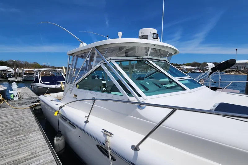 Slide: The Image of 2003 Tiara Yachts 3100 Open LE docked at marina under clear blue sky. - 43