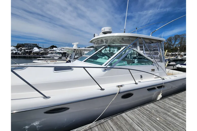 Slide: The Image of 2003 Tiara Yachts 3100 Open LE docked at marina under blue sky. - 44