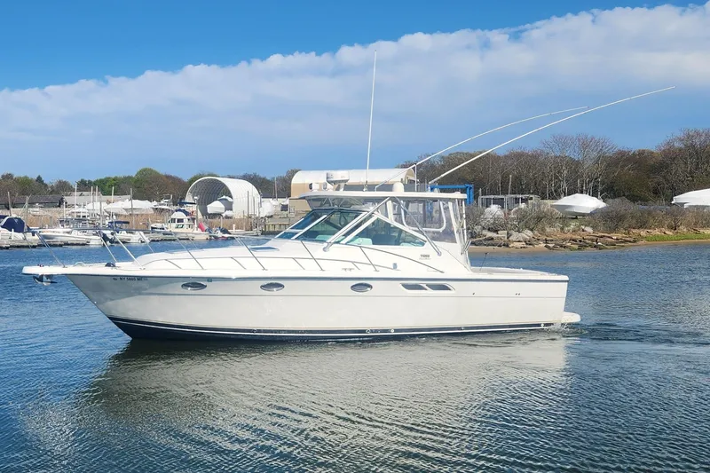 Slide: The Image of 2003 Tiara Yachts 3100 Open LE cruising on calm waters near a marina. - 45